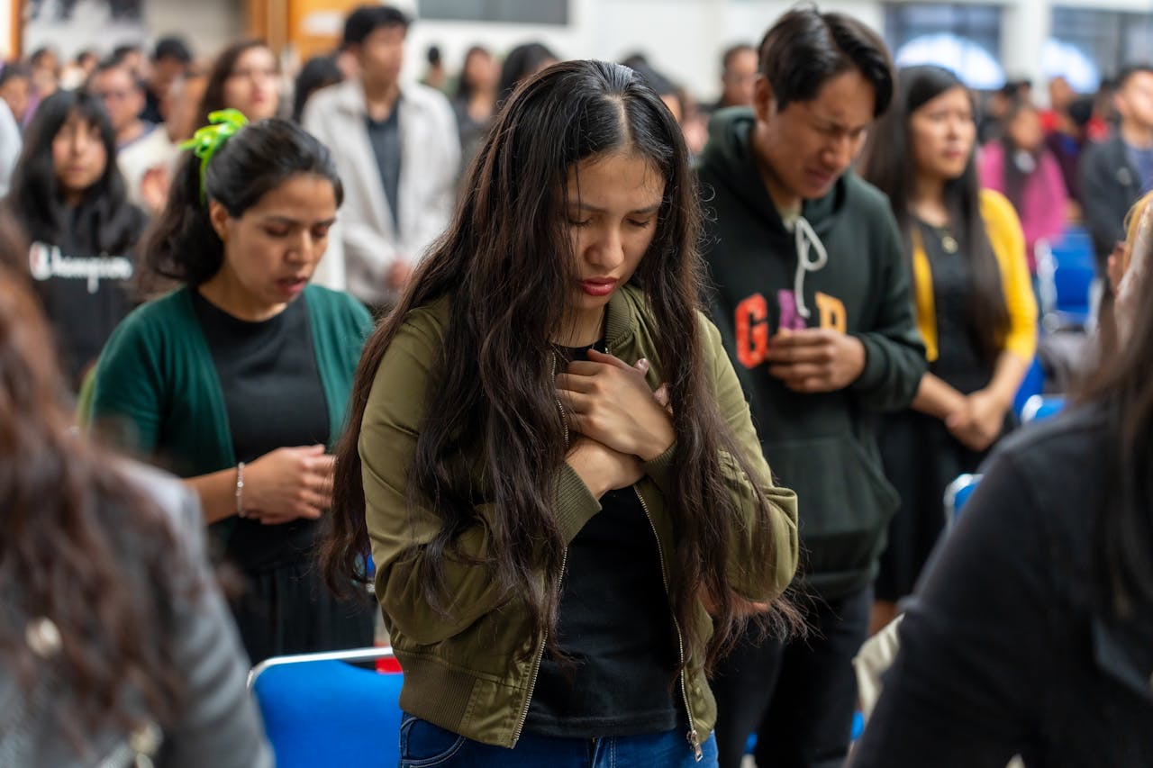 A large group of people engaged in a spiritual gathering and prayer in Ciudad de México.