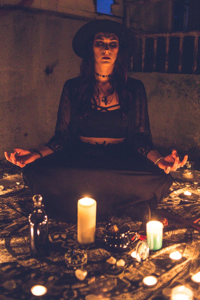 A woman meditating during a candlelit ritual, creating a mystical and mysterious ambiance.